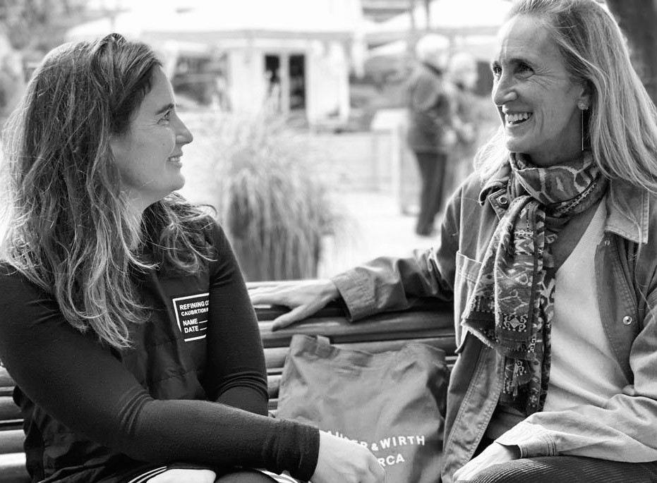 Black and white photograph of Mar Rescalvo and Cristine Bedfor talking.