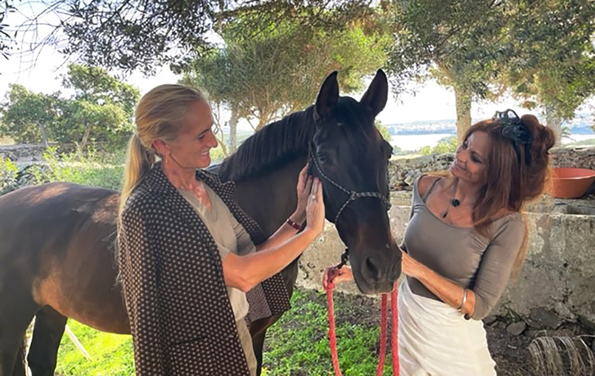 Cristine Bedfor et Sita Moll caressant un cheval dans le champ.